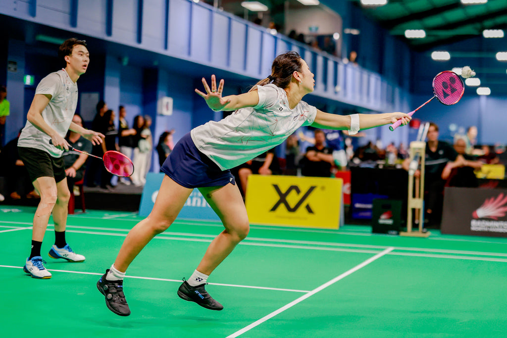Two badminton players in game.